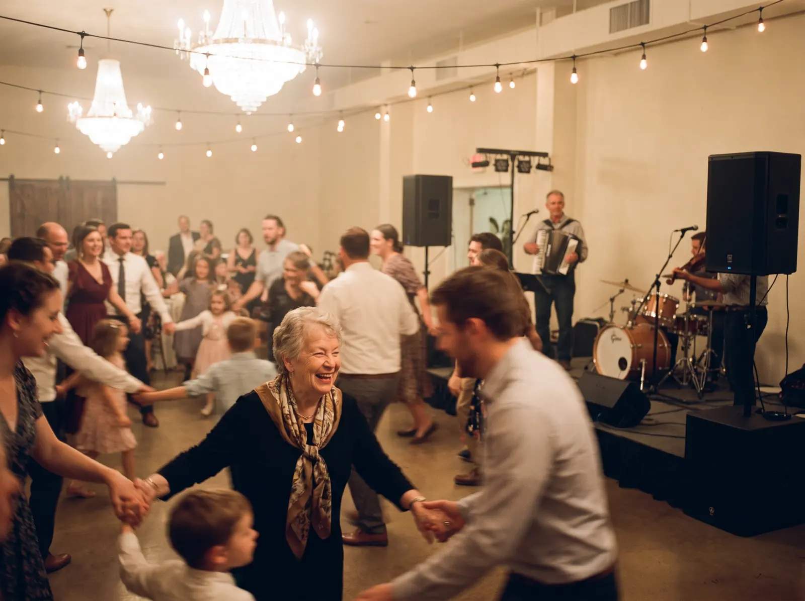 Famille qui danse en ronde, grand-mère, enfants et accordéoniste